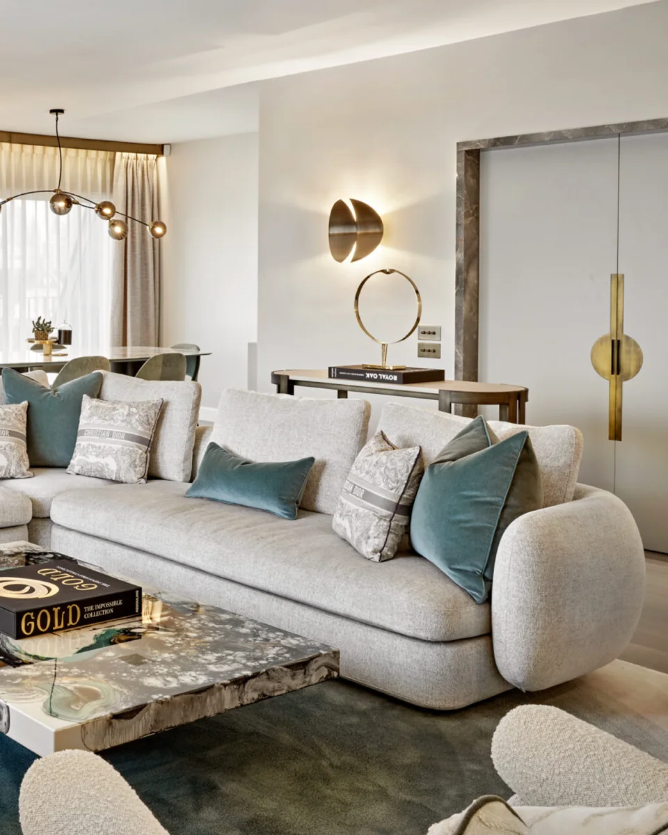 Living room details with a marble coffee table, teal cushions and brass lighting